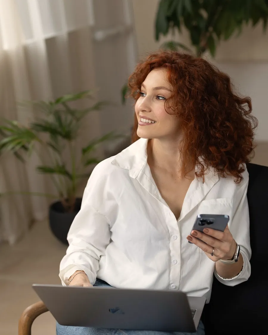 Miki cu laptopul pe genunchi și telefonul în mână